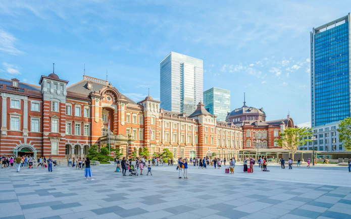 Tokyo Station red brick facade with people walking in the plaza.