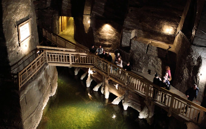Visitors exploring wooden walkways inside Wieliczka Salt Mine, Poland.