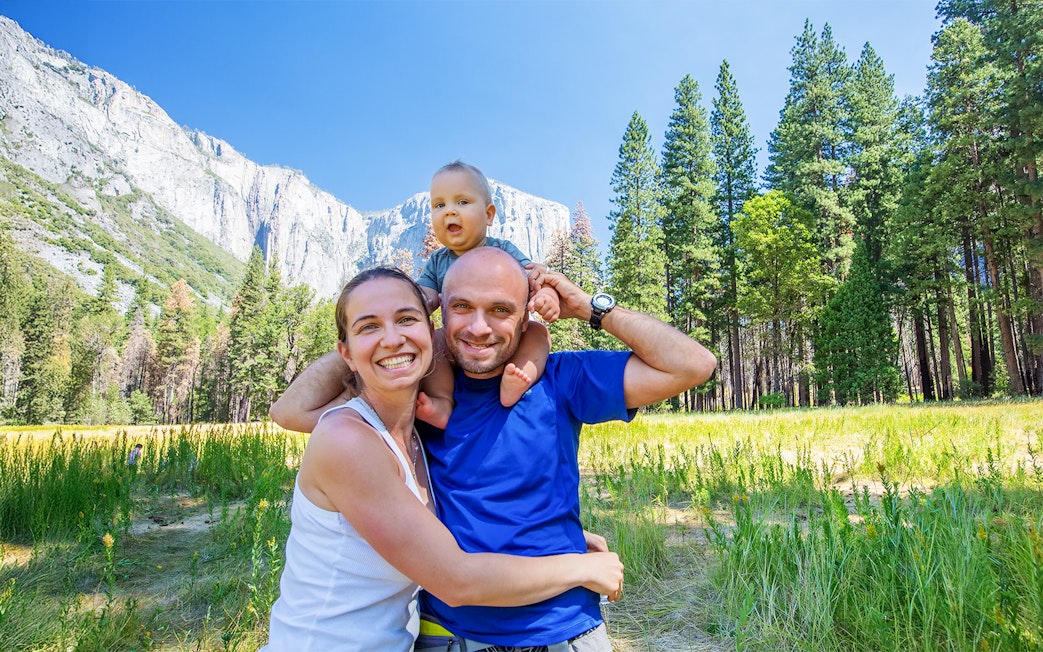 Family with infant enjoying Yosemite National Park, California, with El Capitan in the background.