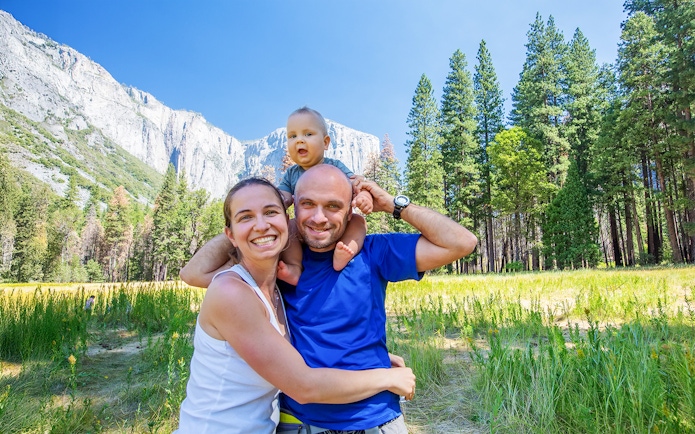 Family with infant enjoying Yosemite National Park, California, with El Capitan in the background.
