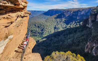 Tour group walking along a cliffside trail in the Blue Mountains, Australia.