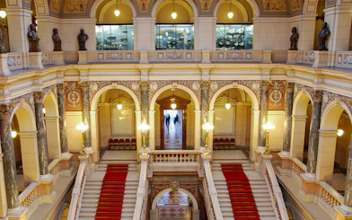 Grand staircase inside the National Museum, Prague, with ornate arches and statues.