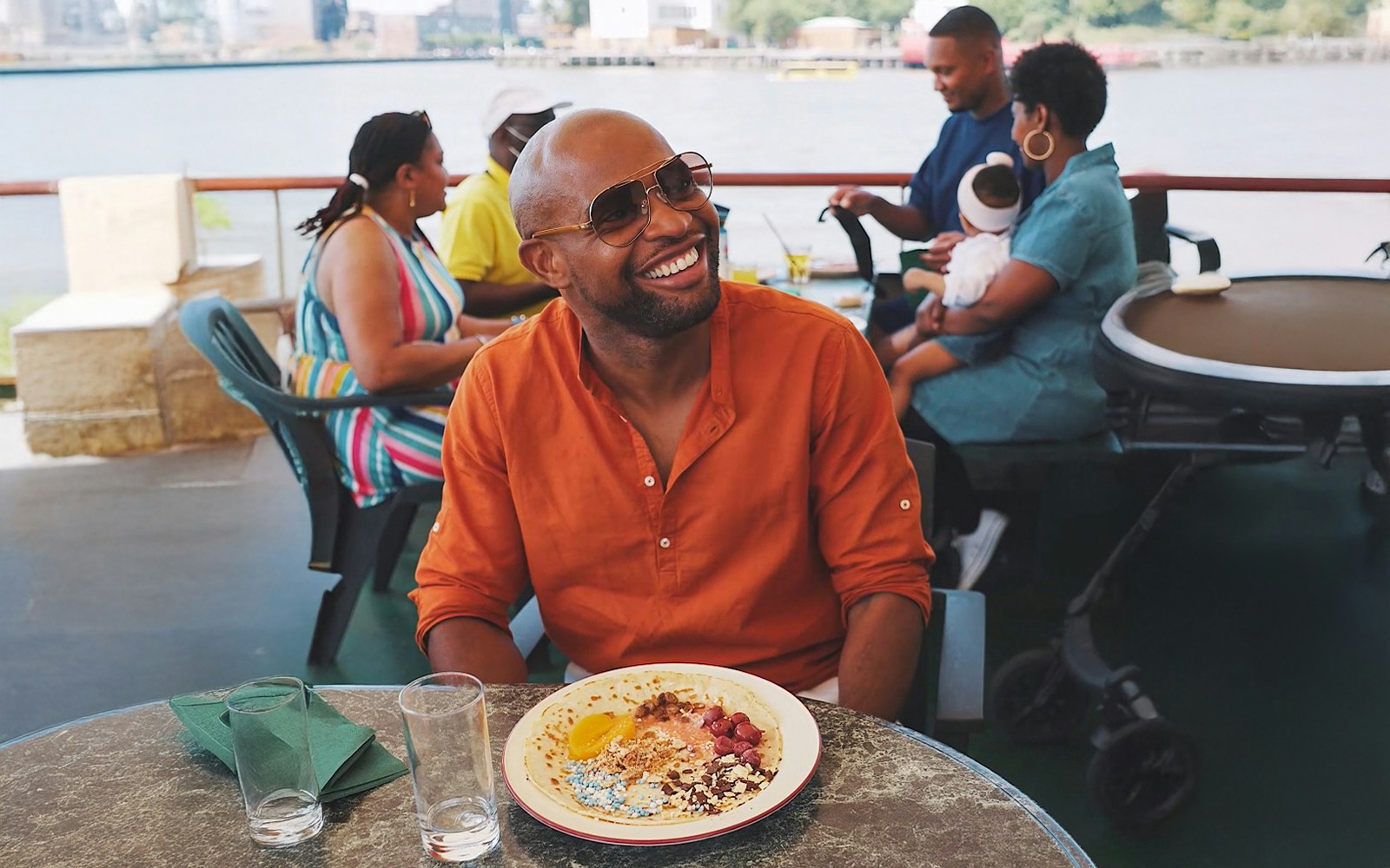 Guests enjoying a scenic view aboard the Pancake Cruise in Rotterdam, with city skyline in the background.
