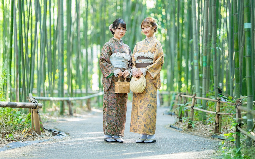 Visitors wearing kimonos in Kyoto's Arashiyama bamboo grove.
