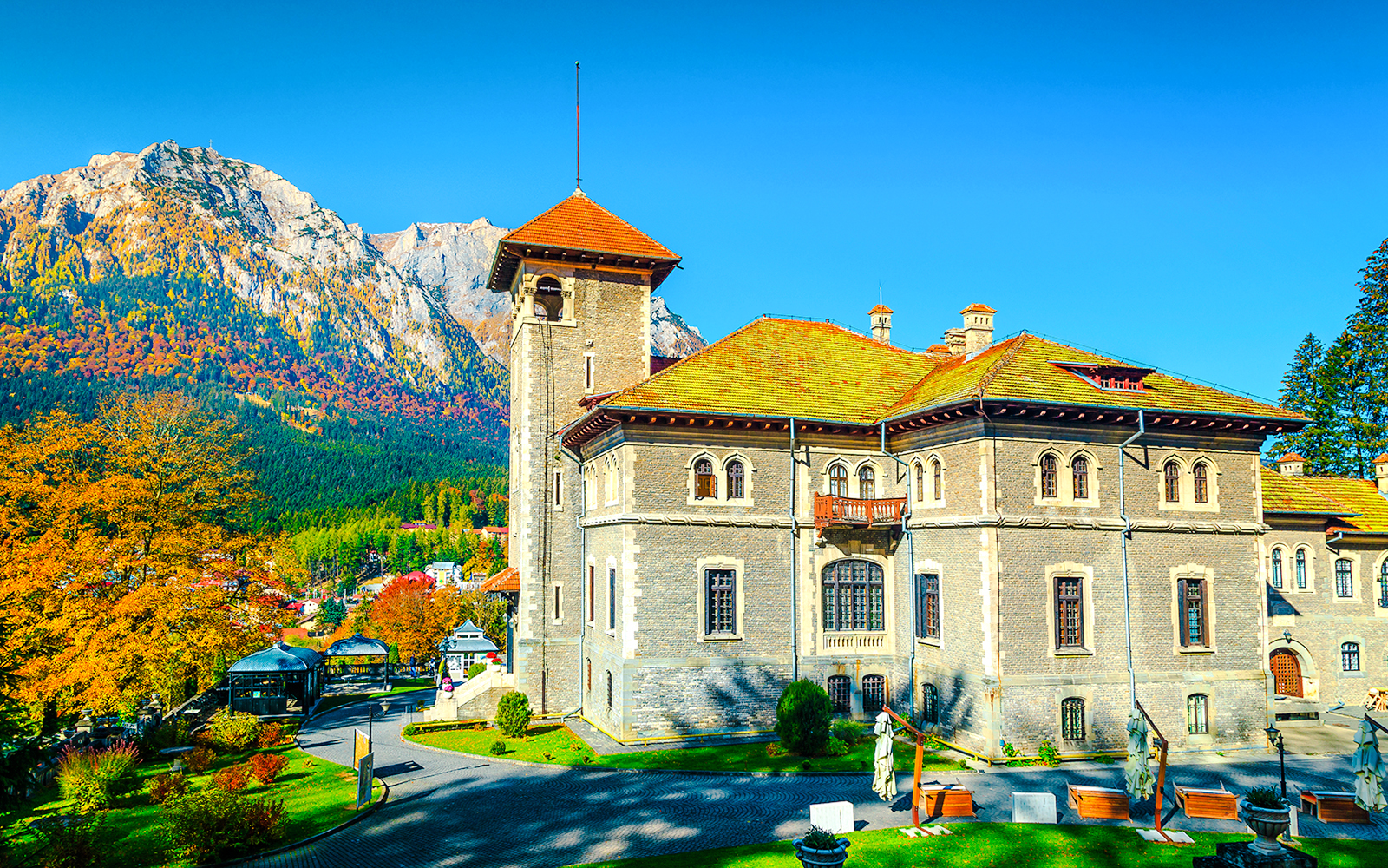 Cantacuzino Castle with garden and mountain backdrop, Romania, Europe.