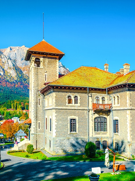 Cantacuzino Castle with garden and mountain backdrop, Romania, Europe.