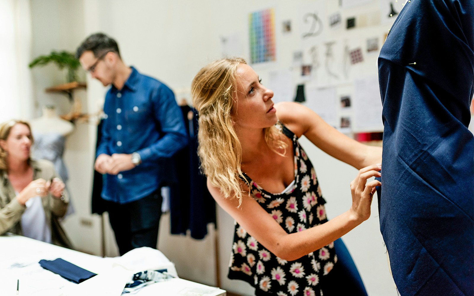 Designer adjusting fabric on mannequin at Fashion and Textile 