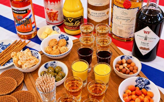 Traditional Dutch drinks and snacks on a table in Amsterdam, featuring genever, advocaat, and stroopwafels.