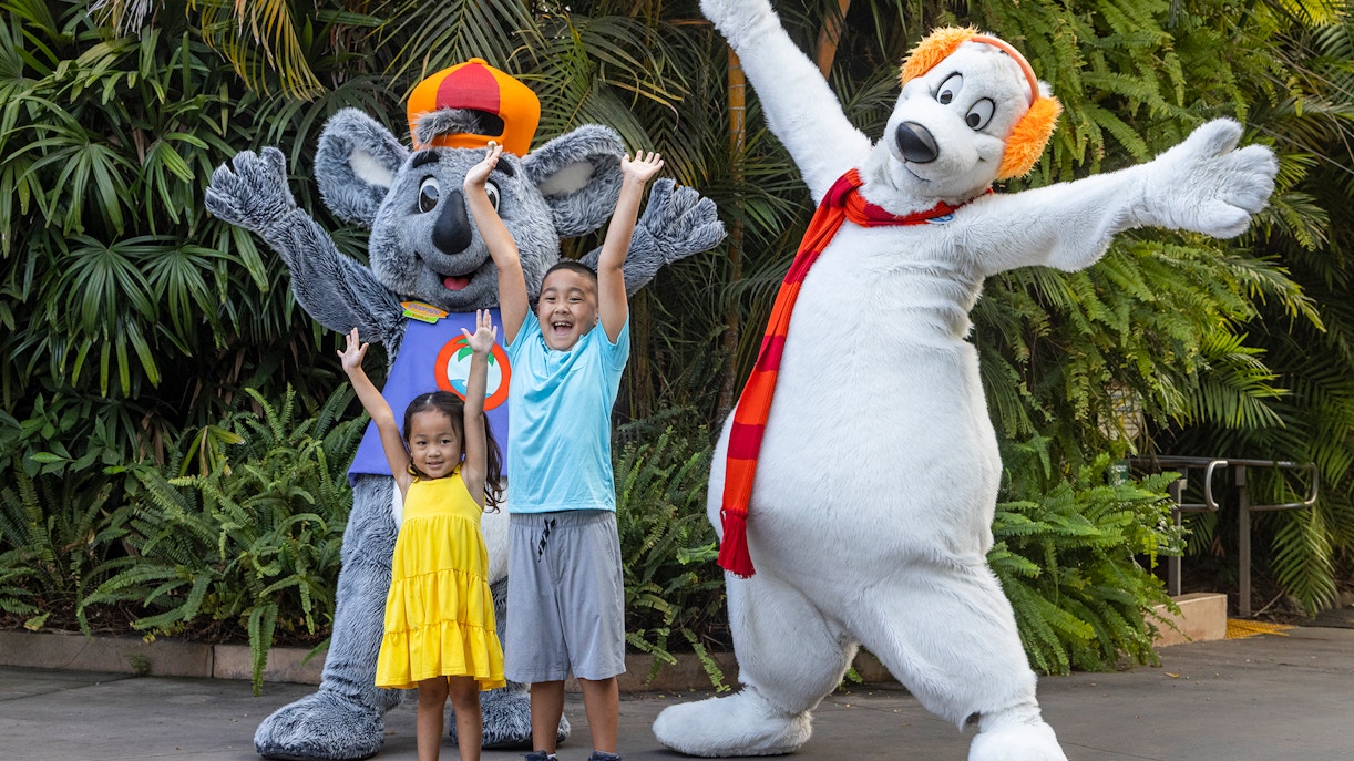 Children posing with animal mascots at San Diego Zoo.