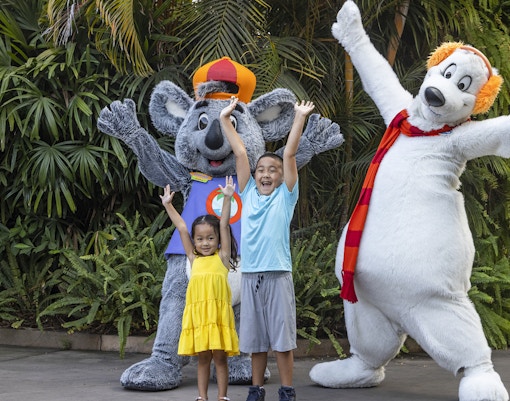 Children posing with animal mascots at San Diego Zoo.