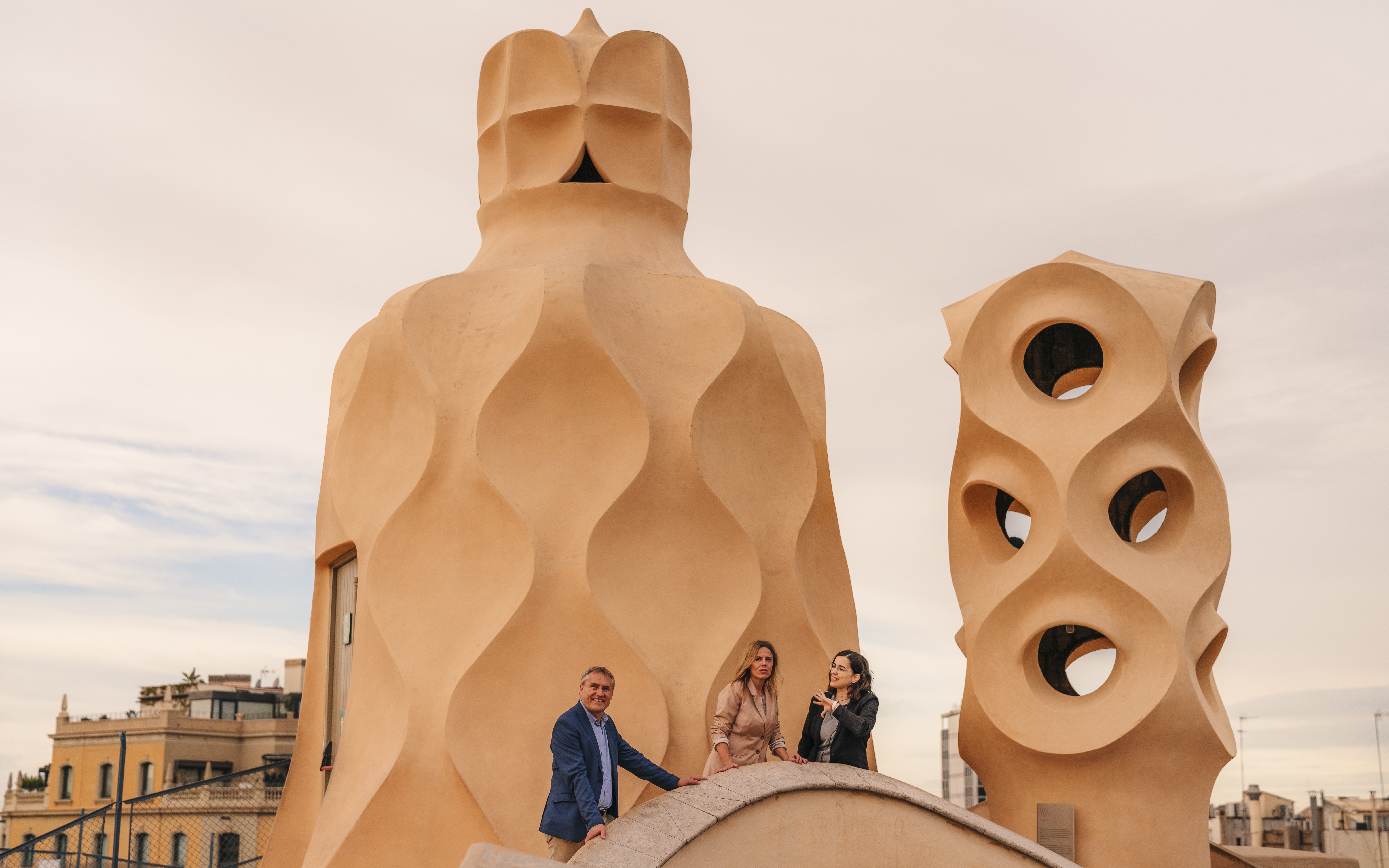 Tourists with guide exploring rooftop architecture at Casa Mila, Barcelona.