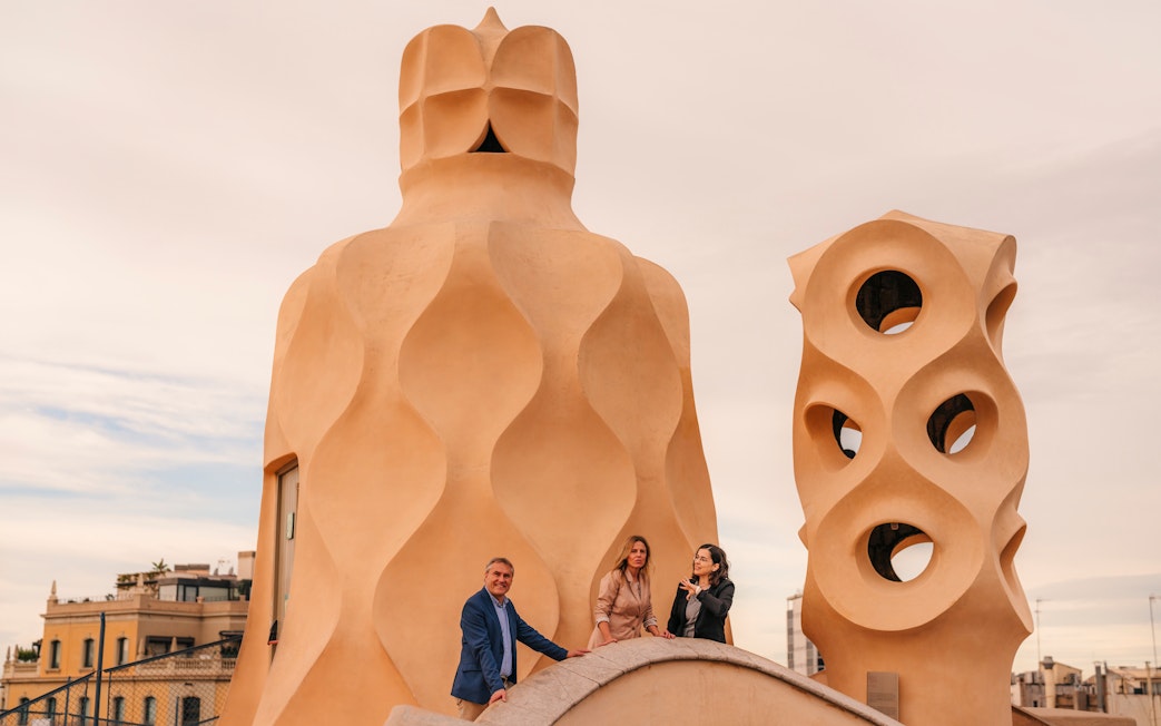 Tourists with guide exploring rooftop architecture at Casa Mila, Barcelona.