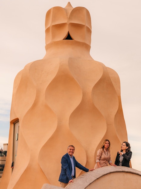 Tourists with guide exploring rooftop architecture at Casa Mila, Barcelona.