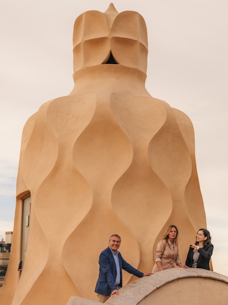 Tourists with guide exploring rooftop architecture at Casa Mila, Barcelona.