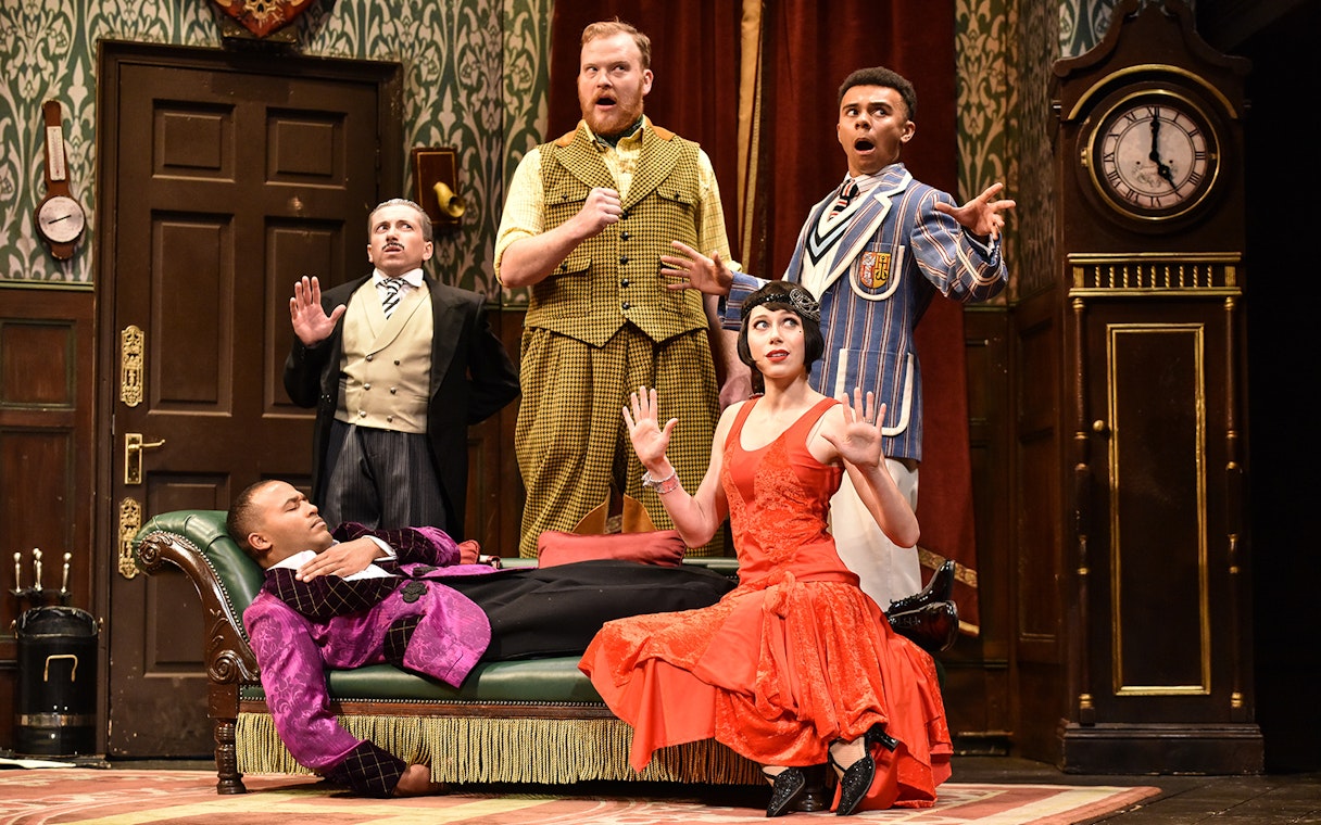 Actors performing a comedic scene in "The Play That Goes Wrong" on stage.