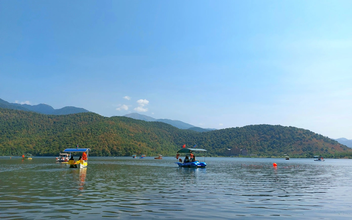 Boats on Nohur Lake with Caucasus Mountains in Gabala, Azerbaijan.