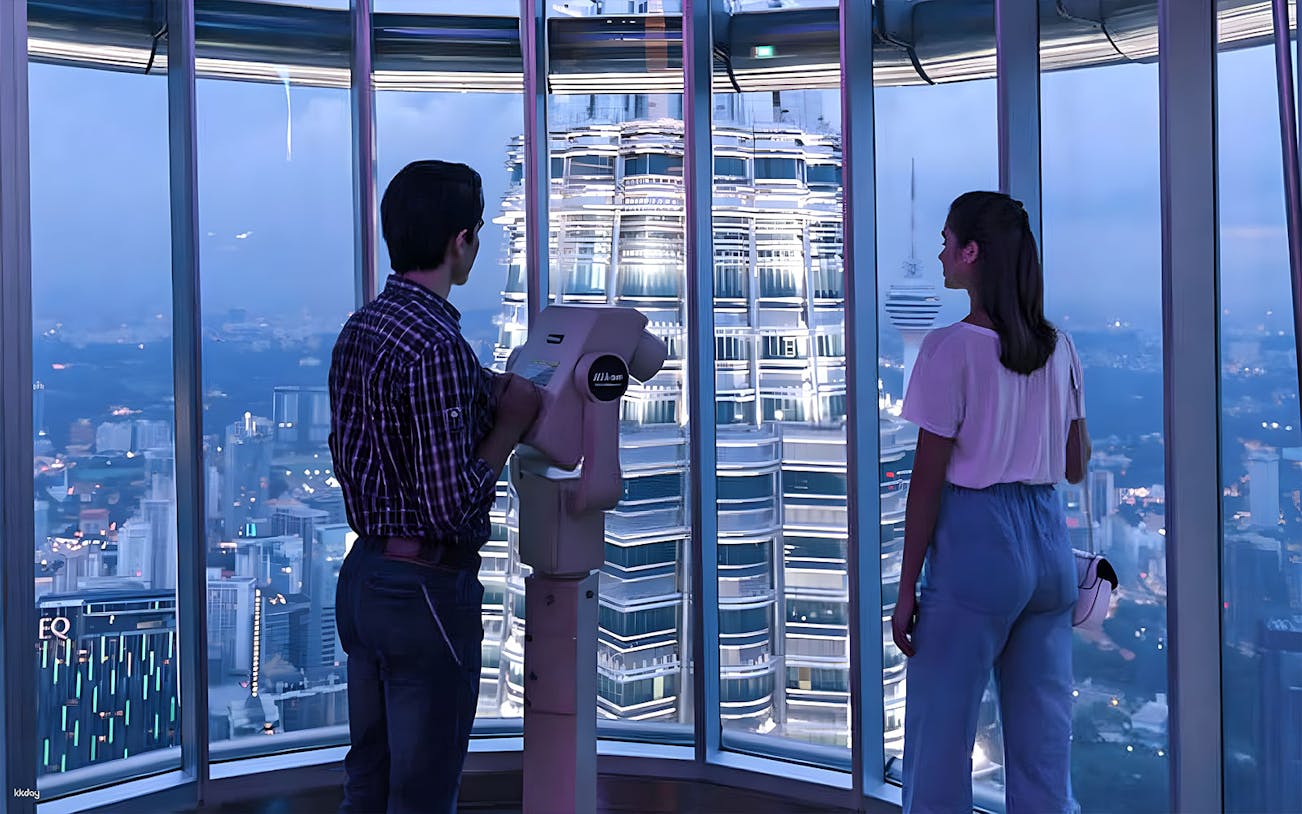 Couple viewing Kuala Lumpur skyline from Petronas Twin Towers observation deck.