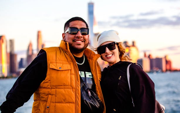 Guests enjoying the Statue of Liberty sightseeing cruise with New York City skyline in background.