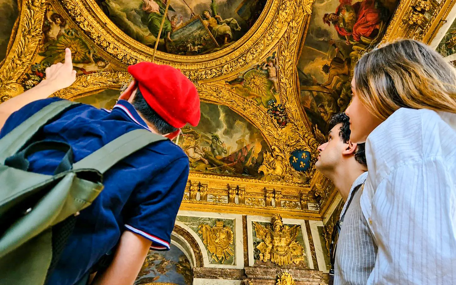 Visitors admire ornate ceiling art in Versailles Palace during a private guided tour.