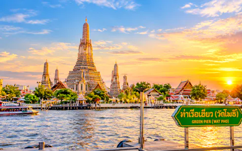 Wat Arun temple by the Chao Phraya River at sunset, Bangkok.