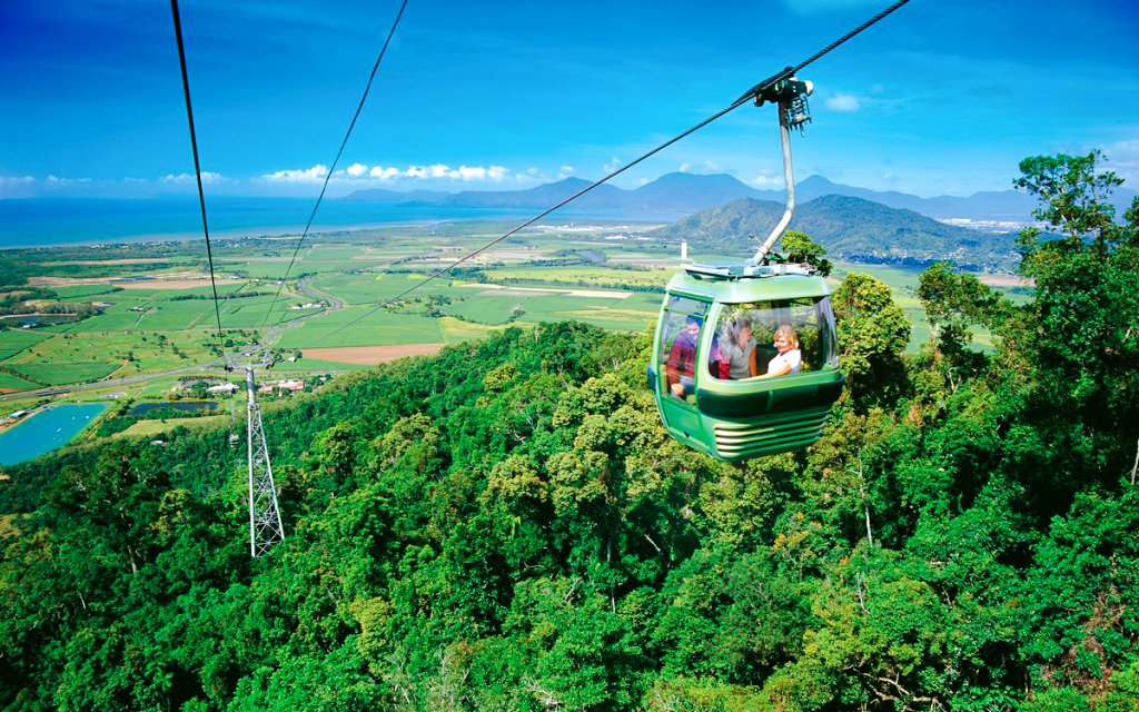 Skyrail gondola over rainforest with views of Kuranda and coastline in Australia.