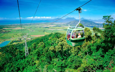 Skyrail gondola over rainforest with views of Kuranda and coastline in Australia.