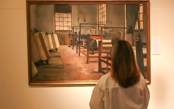 Visitor viewing artwork at Modernism Museum Barcelona's 4 Cats exhibit.