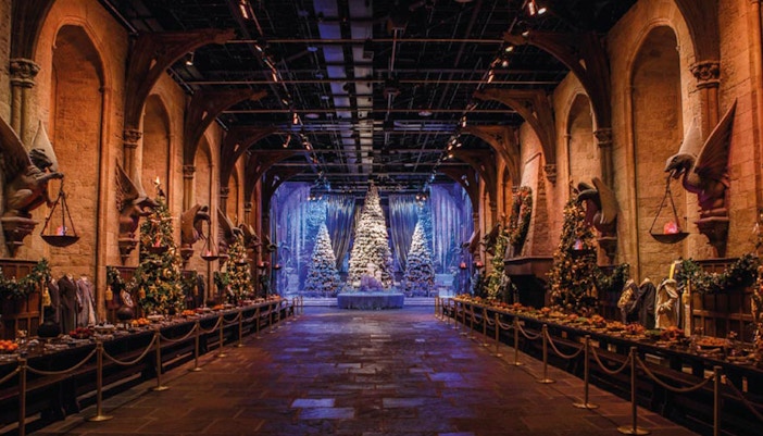 Harry Potter Studio London decorated for Christmas with festive lights and Hogwarts model.