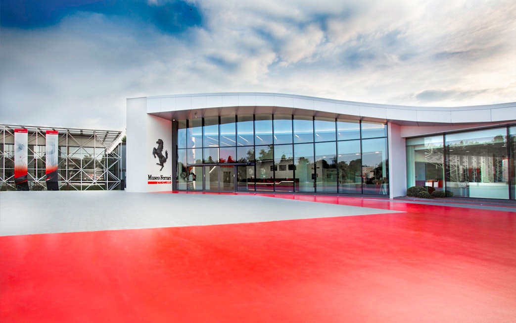 Exterior view of Ferrari Museum in Maranello with modern glass facade.