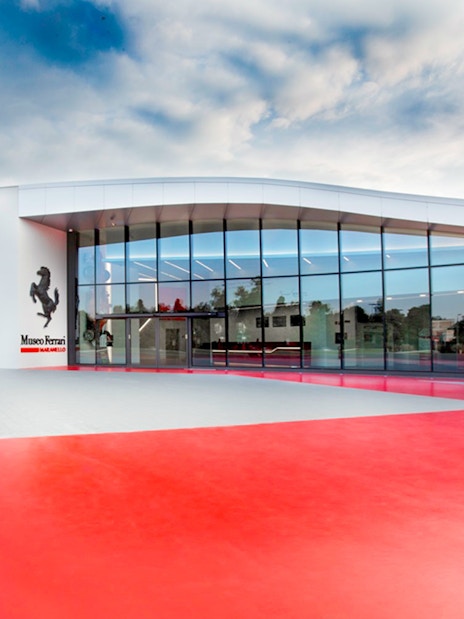 Exterior view of Ferrari Museum in Maranello with modern glass facade.
