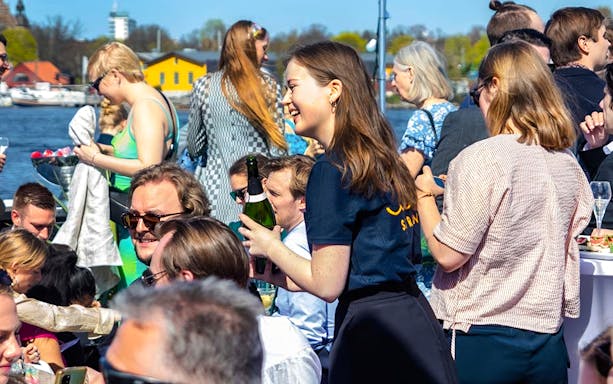 People enjoying Stockholm Harbor Archipelago Cruise with drinks and scenic views.
