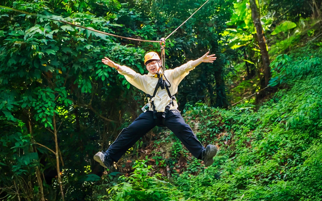 Ziplining through lush forest at Flying Hanuman, Phuket, Thailand.