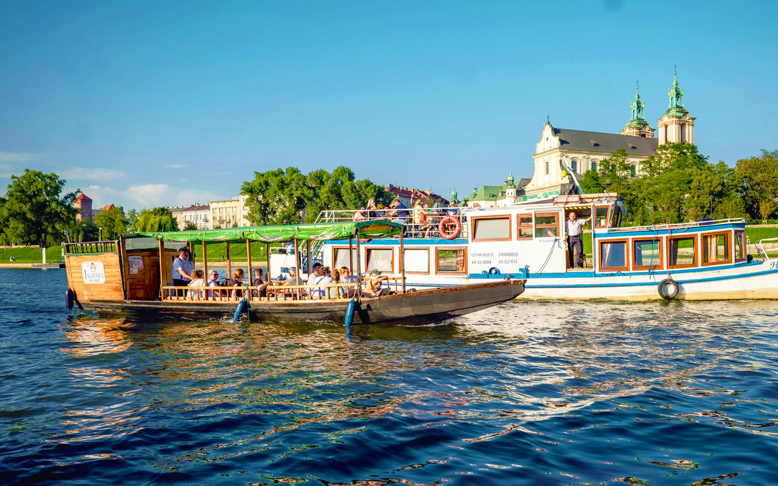 Vistula river cruise boat near the Church on the Rock in Krakow, Poland.