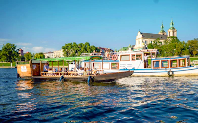 Vistula river cruise boat near the Church on the Rock in Krakow, Poland.