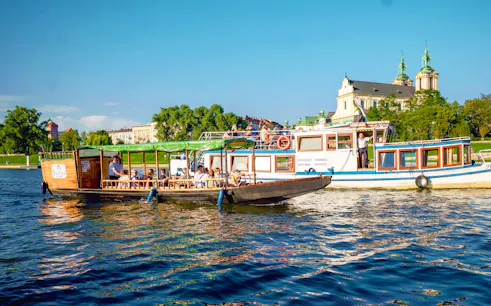 Vistula river cruise boat near the Church on the Rock in Krakow, Poland.