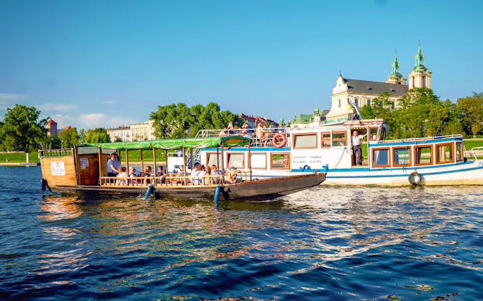 Vistula river cruise boat near the Church on the Rock in Krakow, Poland.