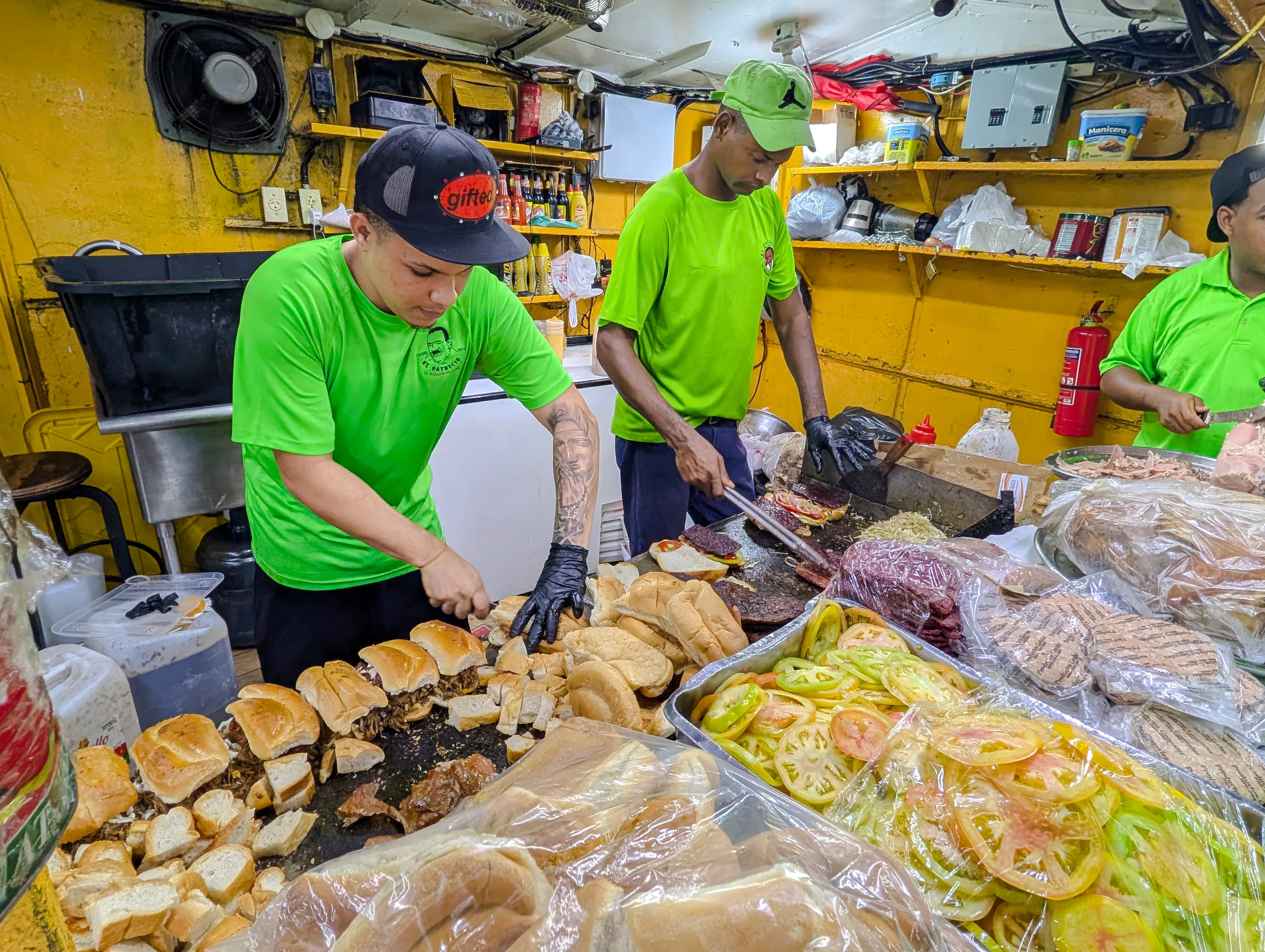 Street food vendors preparing sandwiches in Santo Domingo, part of the Punta Cana night food tour.