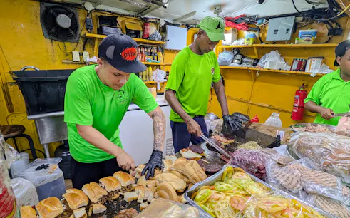 Street food vendors preparing sandwiches in Santo Domingo, part of the Punta Cana night food tour.