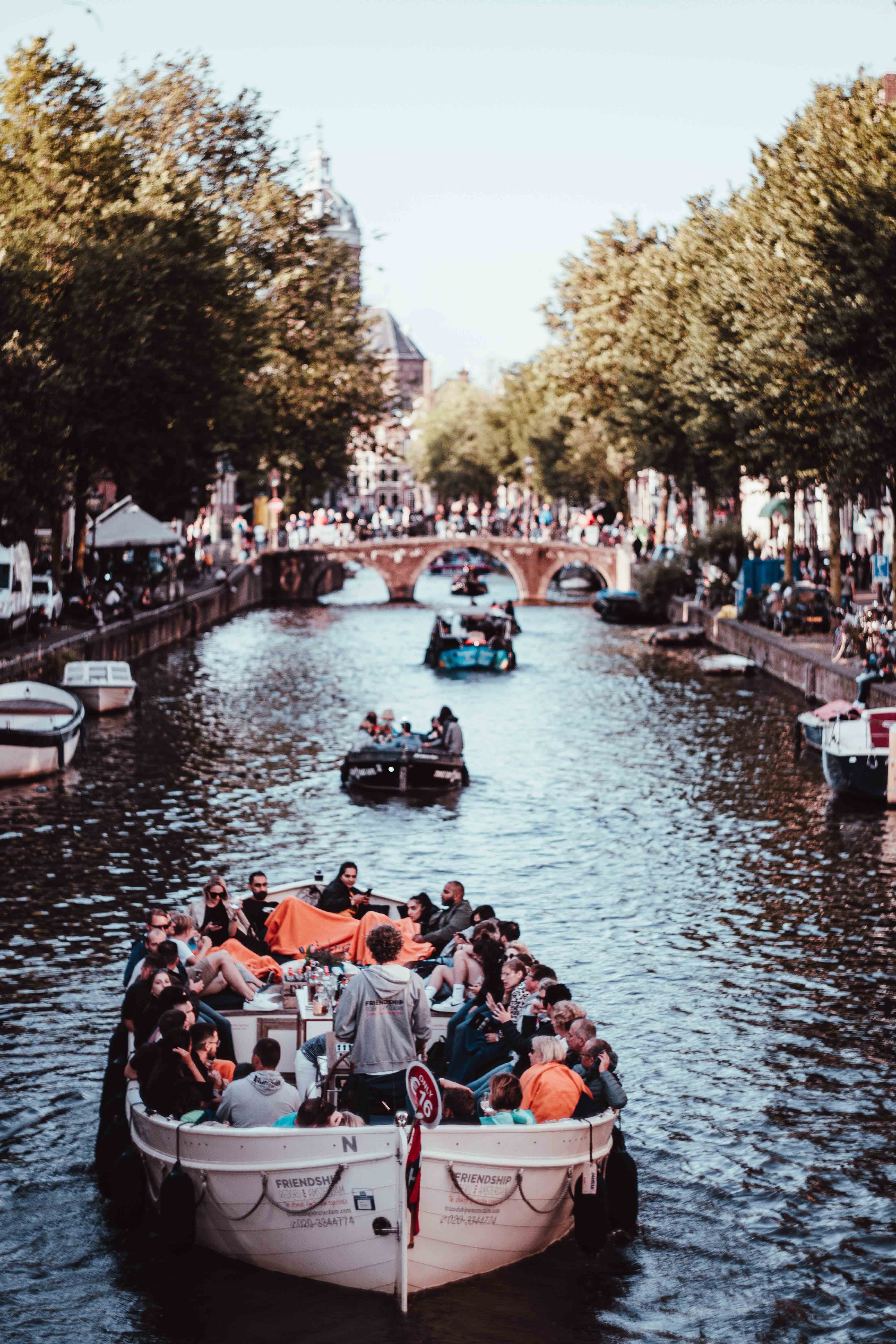Amsterdam canal boat cruise with historic buildings and bridges in view.