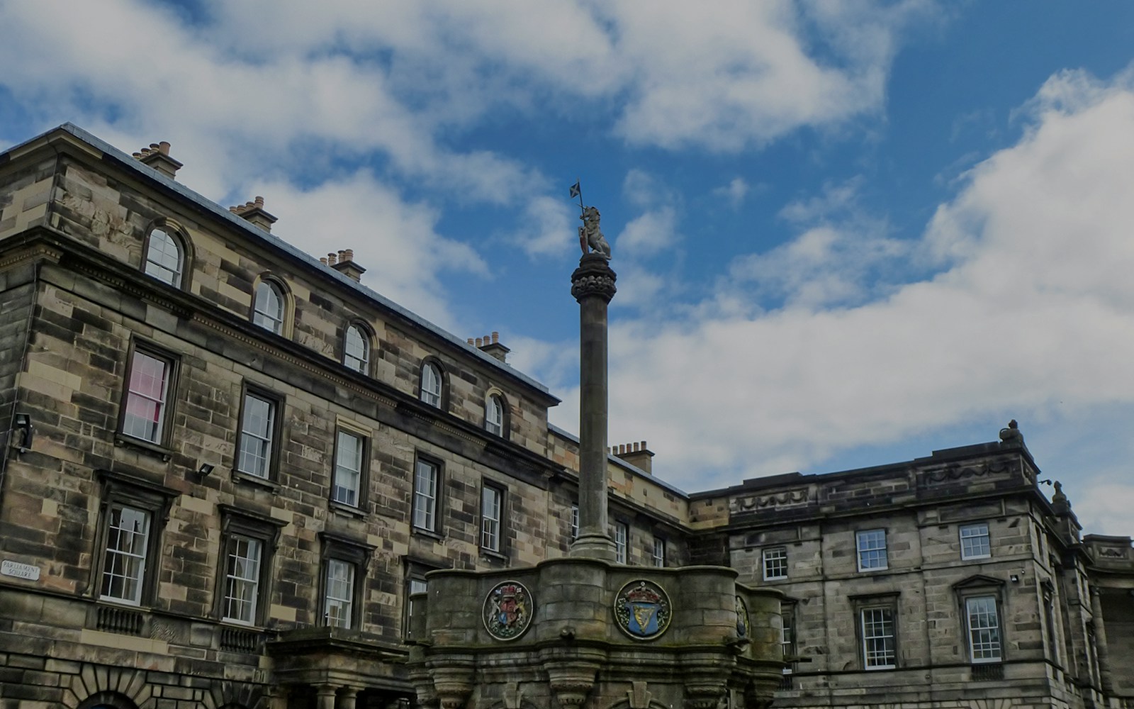 Mercat Cross with Royal Unicorn and heraldic medallions in Old Town, Edinburgh.