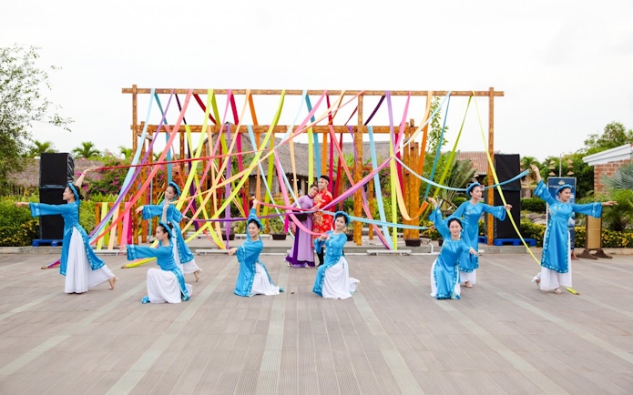Performers in traditional attire at Hoi An Memories Show with colorful ribbons.