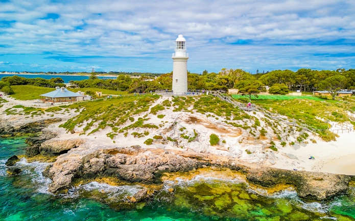 Aerial view of Bathurst Lighthouse on Rottnest Island with surrounding greenery and coastline.