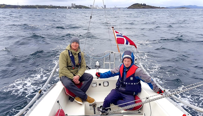 Guests sailing on Stavanger Fjord, Norway, with scenic mountain views in the background.