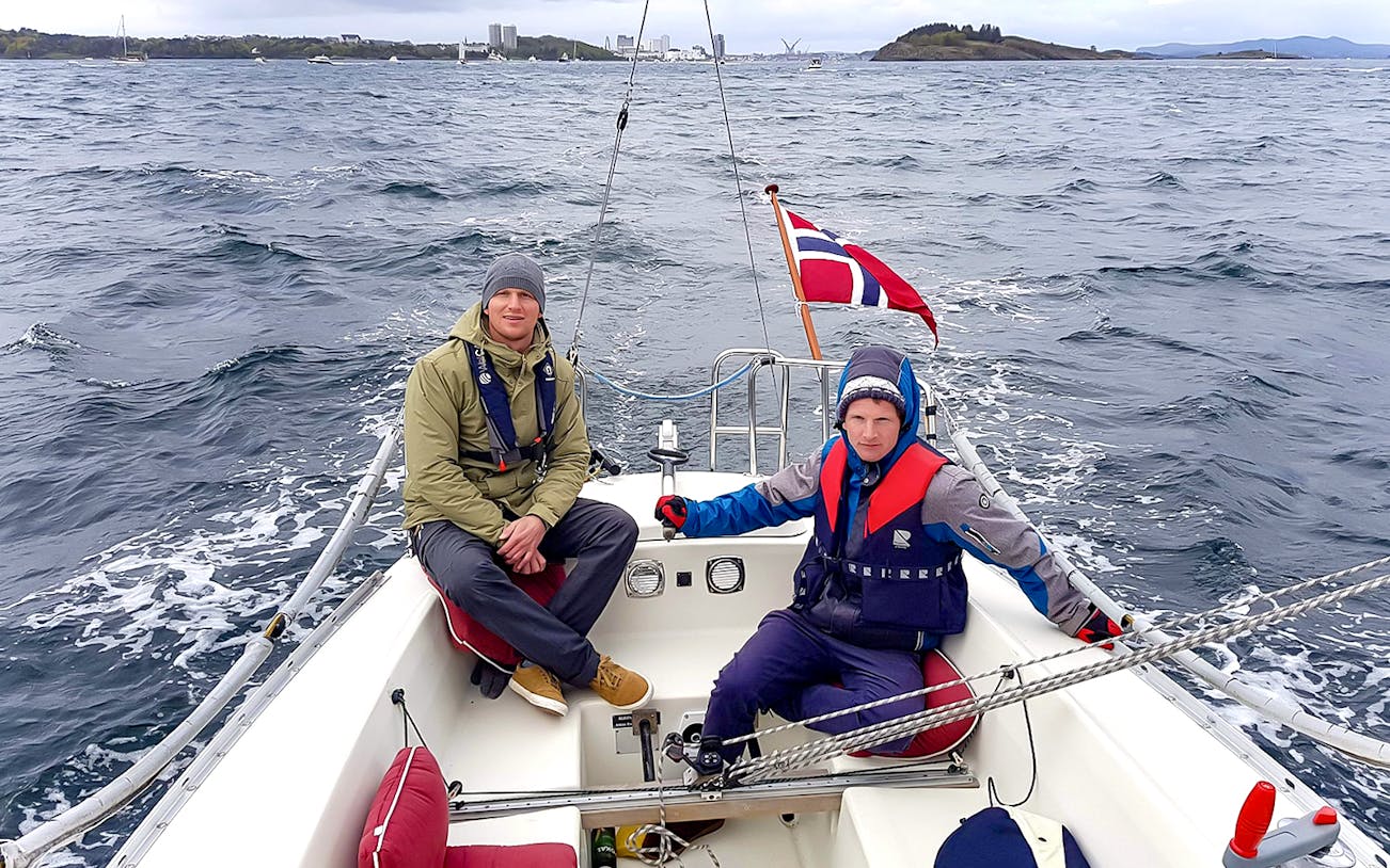 Guests sailing on Stavanger Fjord with Norwegian flag in view.