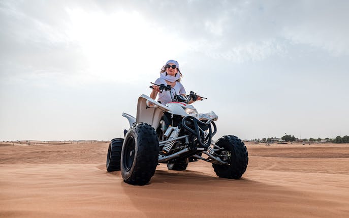 Person riding an ATV on Dubai desert safari.
