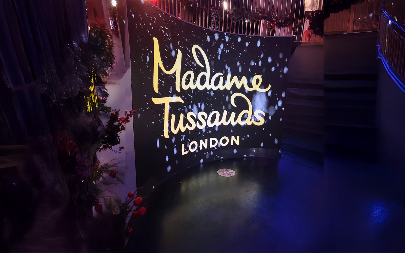 Large plasma at entrance screen with neon lighting reading "Madame Tussauds London"