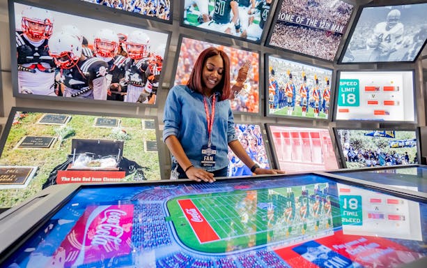 Woman interacting with digital display at Chick-fil-A College Football Hall of Fame.