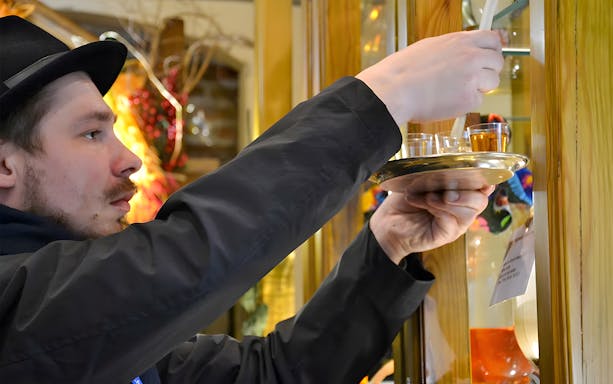 Man pouring craft beer samples in Kraków bar during walking tour.
