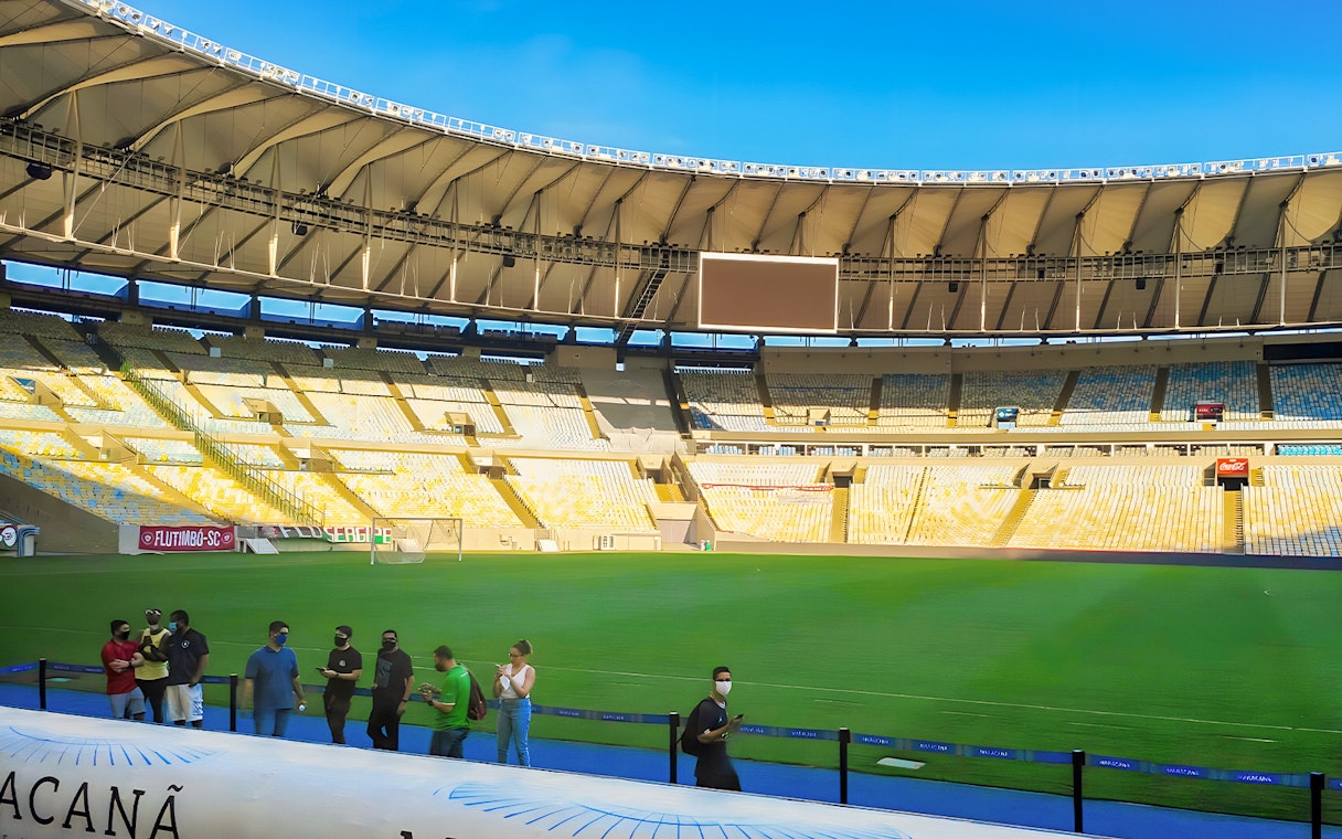 Maracanã Stadium field with visitors walking along the perimeter in Rio de Janeiro, Brazil.