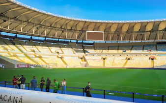 Maracanã Stadium field with visitors walking along the perimeter in Rio de Janeiro, Brazil.